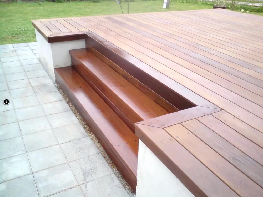 Hyggelig træterrasse i naturligt look omgivet af en frodig have